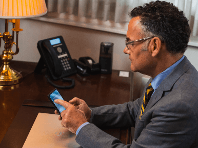 Funeral director holding his mobile phone, using the ASD mobile app