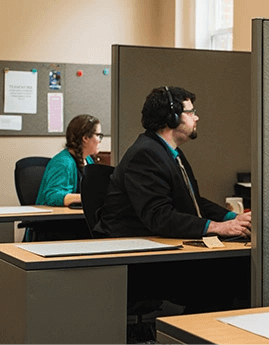 Three ASD call specialists working at their desks in the office