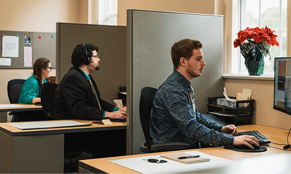 Three ASD call specialists working at their desks in the office