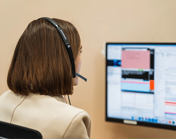 ASD Call Specialist looking at a computer screen while taking a call on her headset